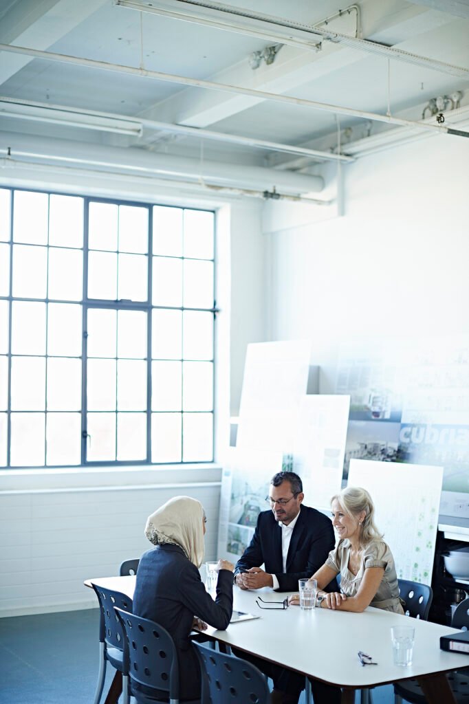 two businesswomen and man talking at office meeting